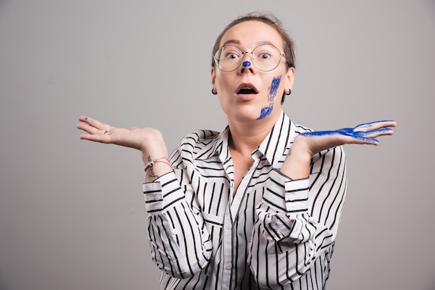 Kostenlose Foto frau, die ihre farbenhände auf grauem hintergrund zeigt