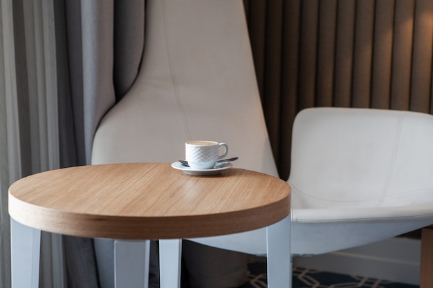 Free Photo side view cup of coffee on a small round table horizontal