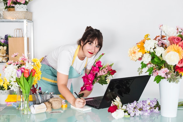 Miễn phí Photo chân dung một nữ người bán hoa với những bông hoa viết trên notepad