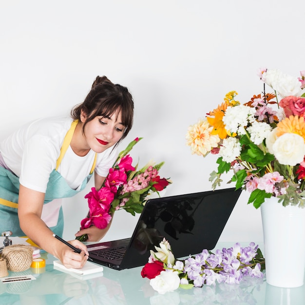 Miễn phí Photo nữ người bán hoa viết trên notepad trong cửa hàng hoa