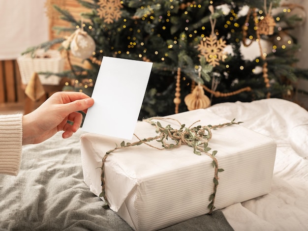 Photo gift certificate card mockup and christmas gift on winter holiday